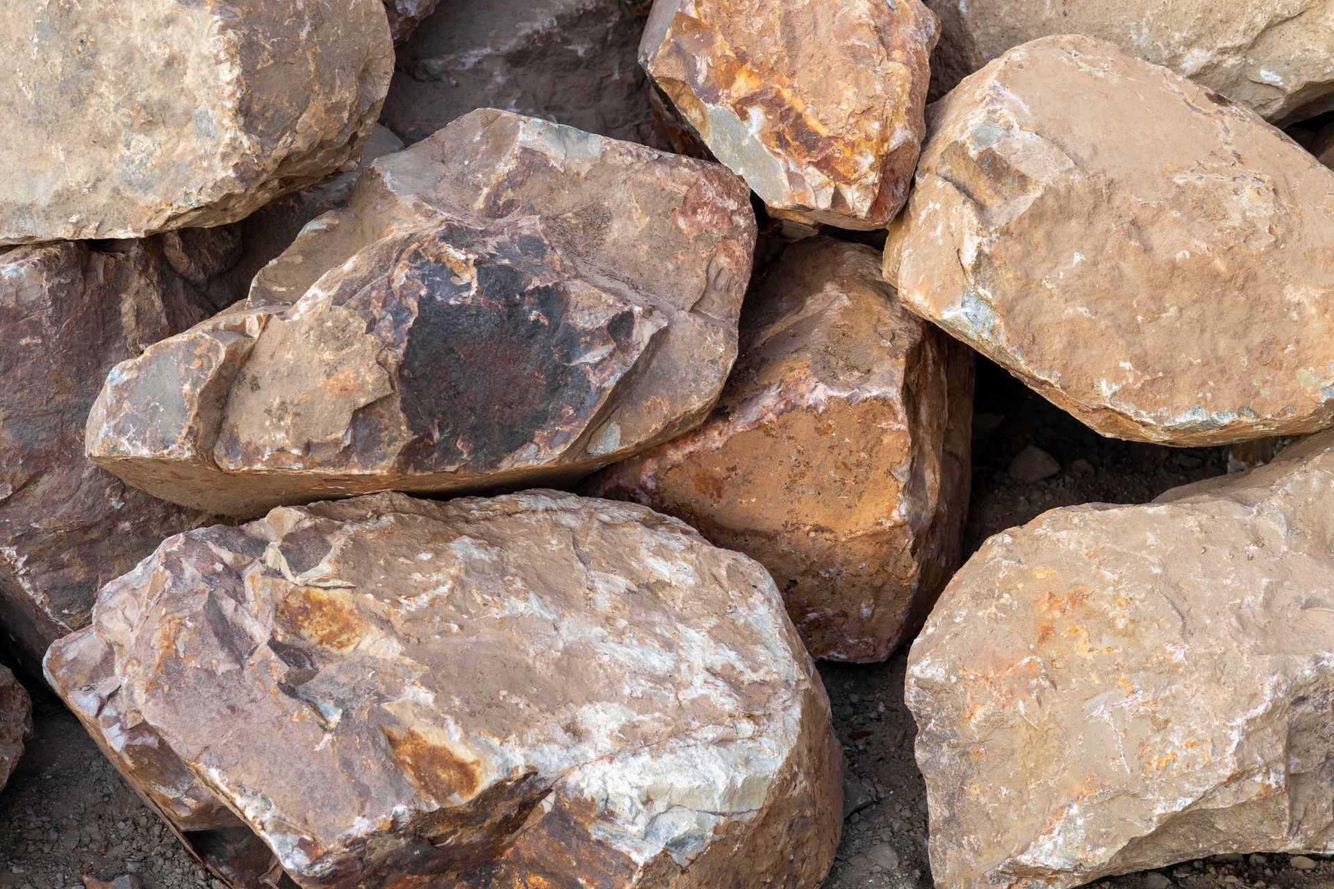 Pile of rough, tan and brown rocks stacked closely together