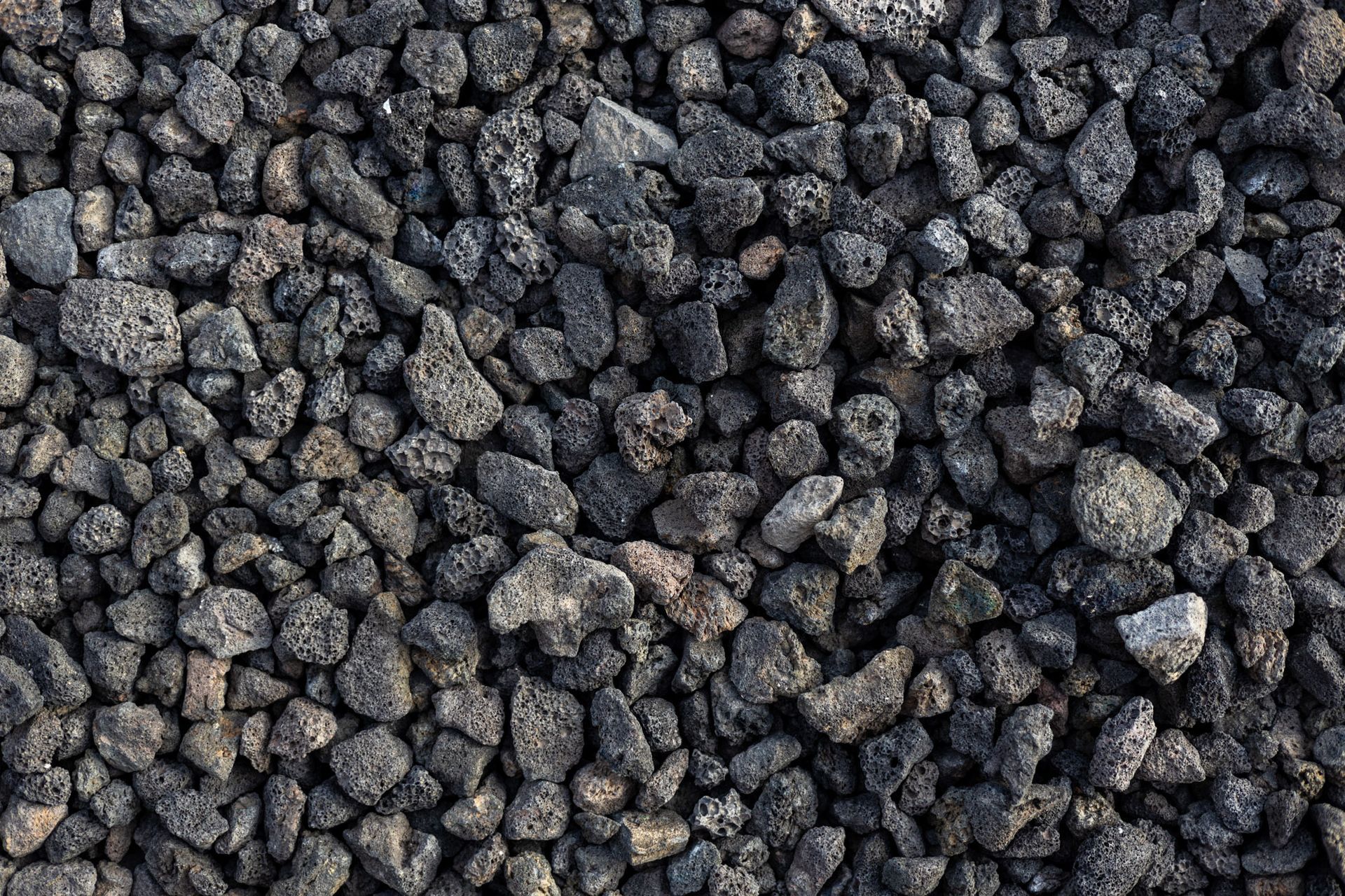 Close-up of small dark gray rocks or gravel covering the frame