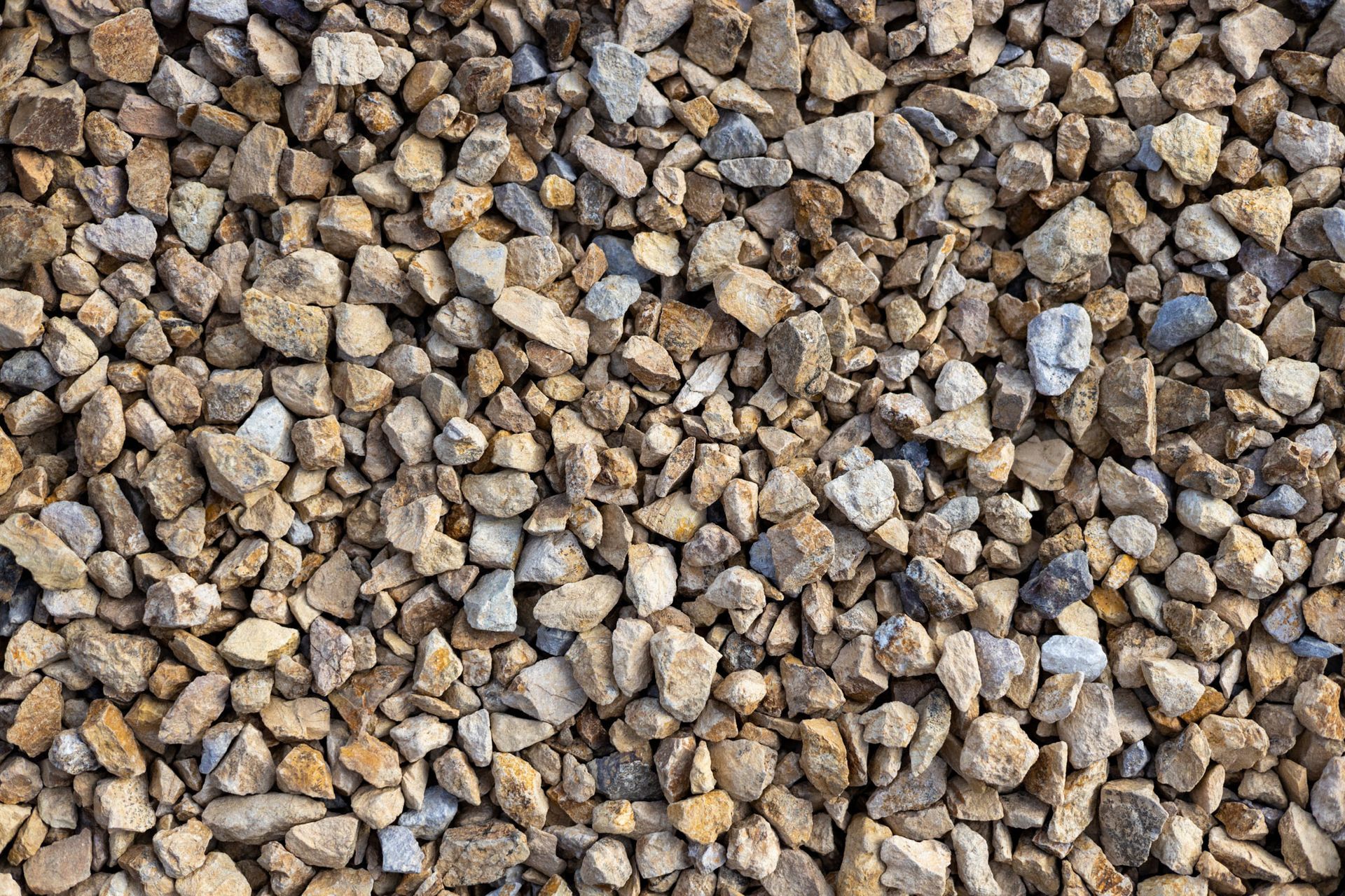 Close-up of small tan and gray gravel stones filling the frame