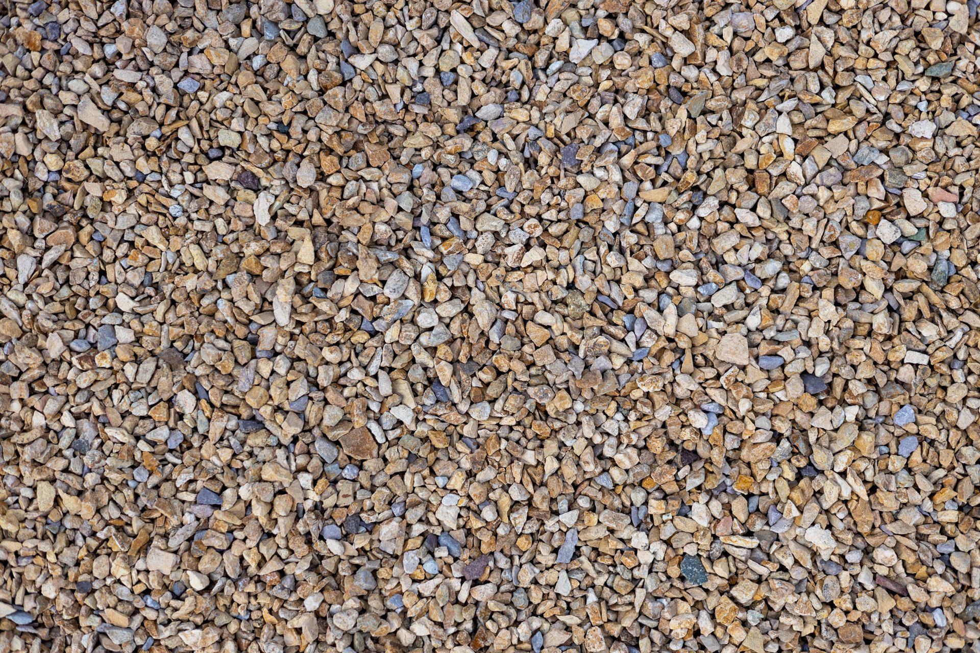 Close-up of small tan and gray gravel stones filling the frame