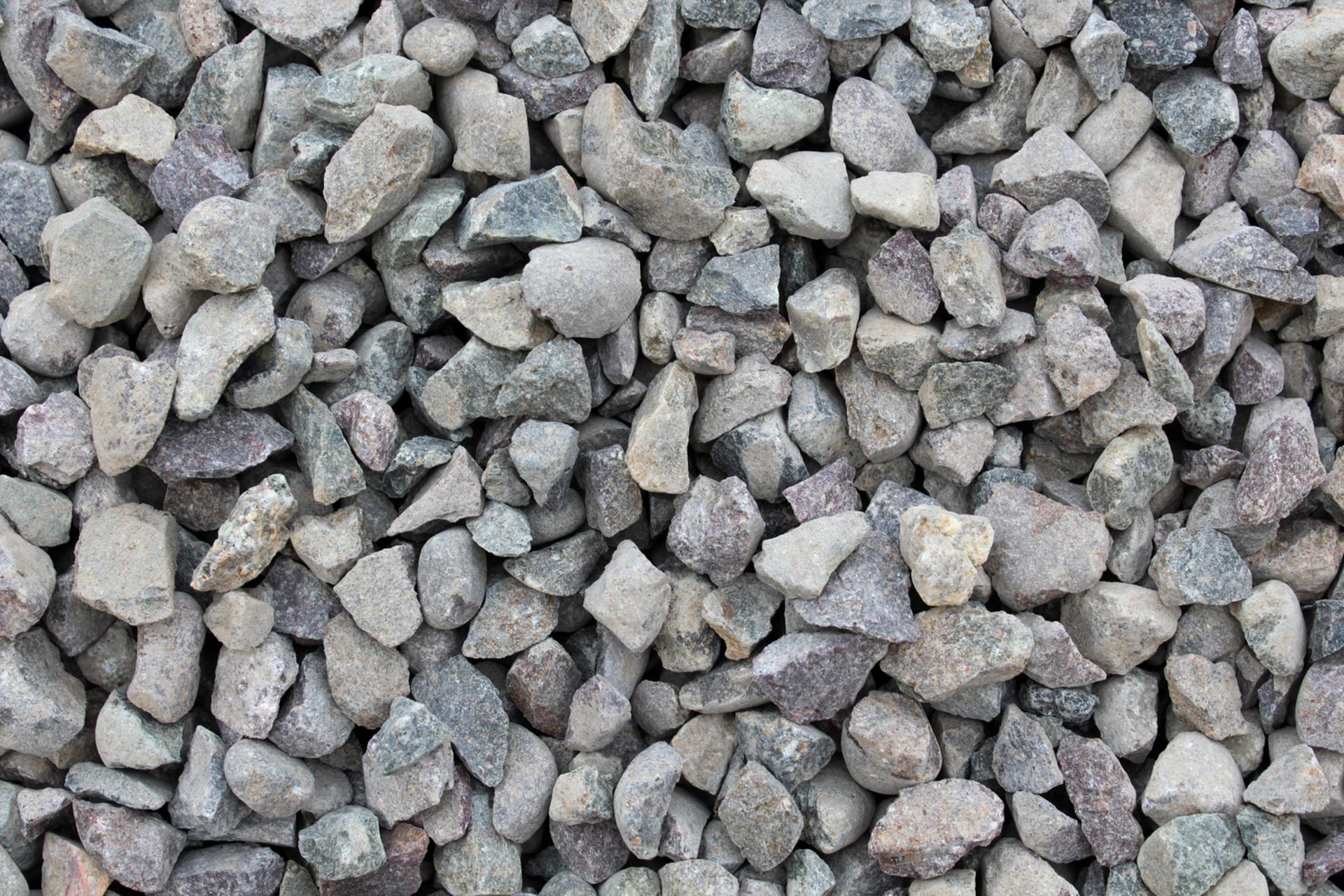 Gray gravel stones filling the frame, showing a close-up of rough rock texture.