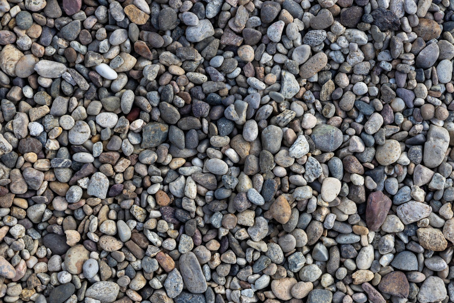Close-up of smooth gray and brown pebbles filling the frame