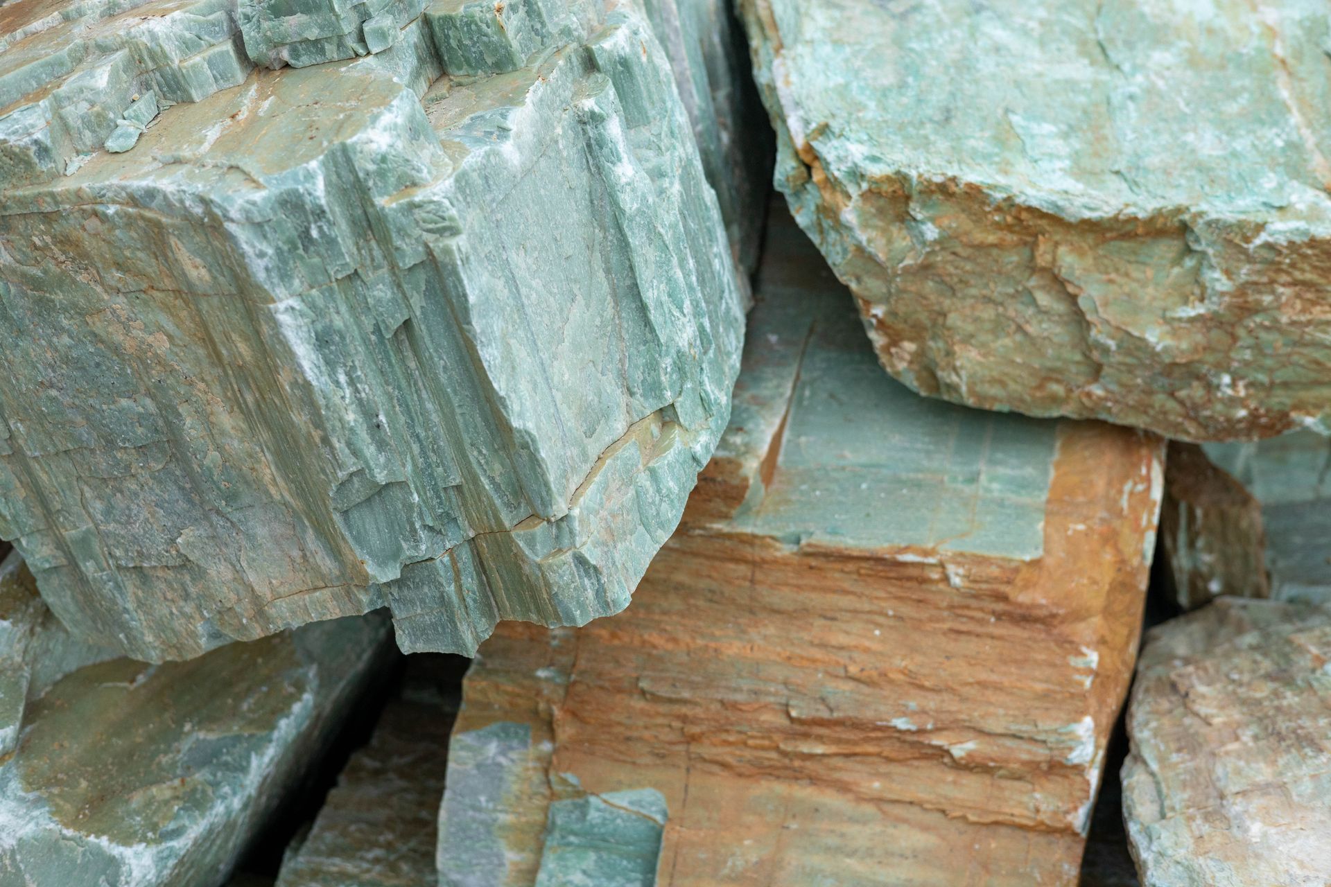 Stacked gray and tan stone blocks on dirt ground