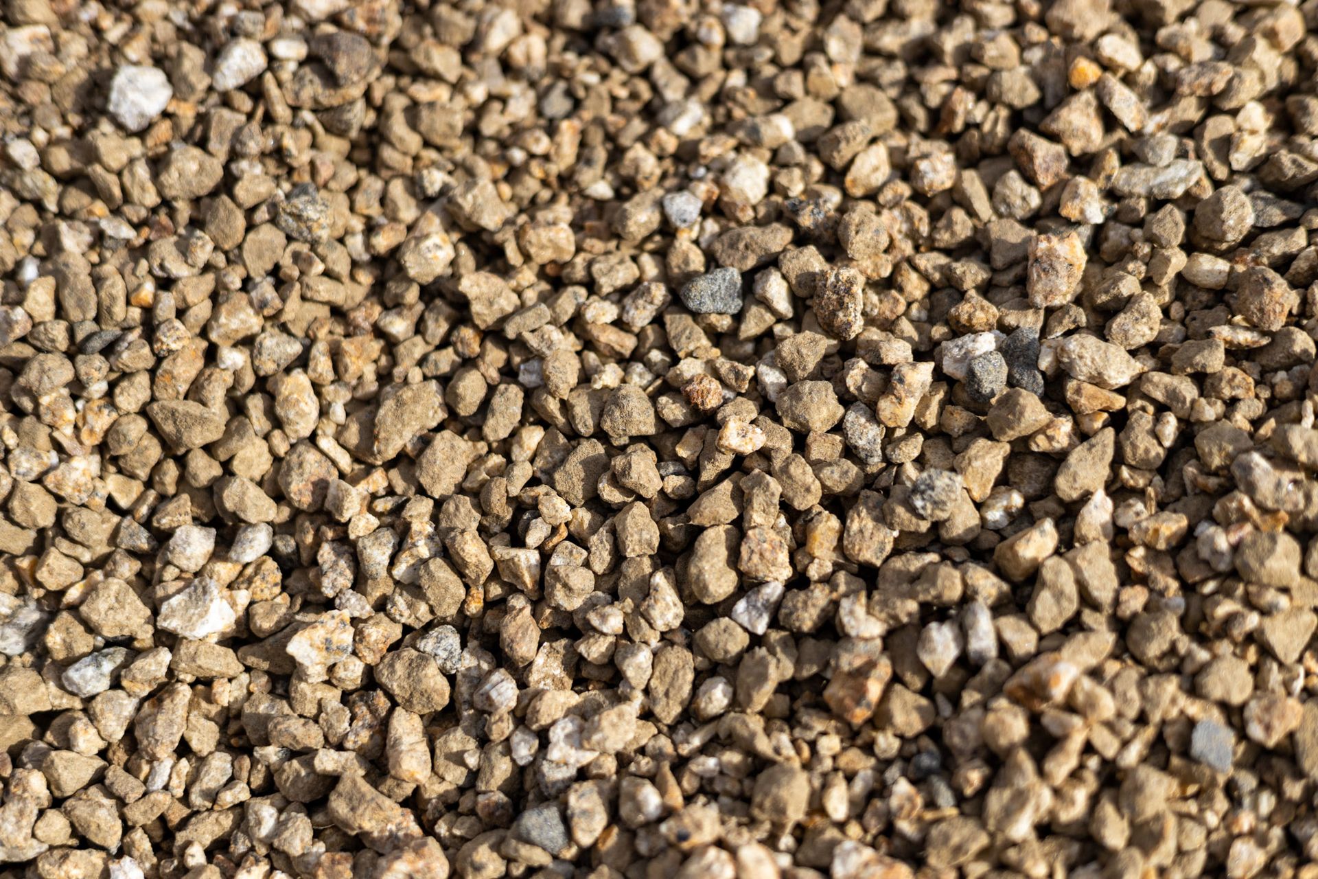 Close-up of small tan and brown gravel stones filling the frame