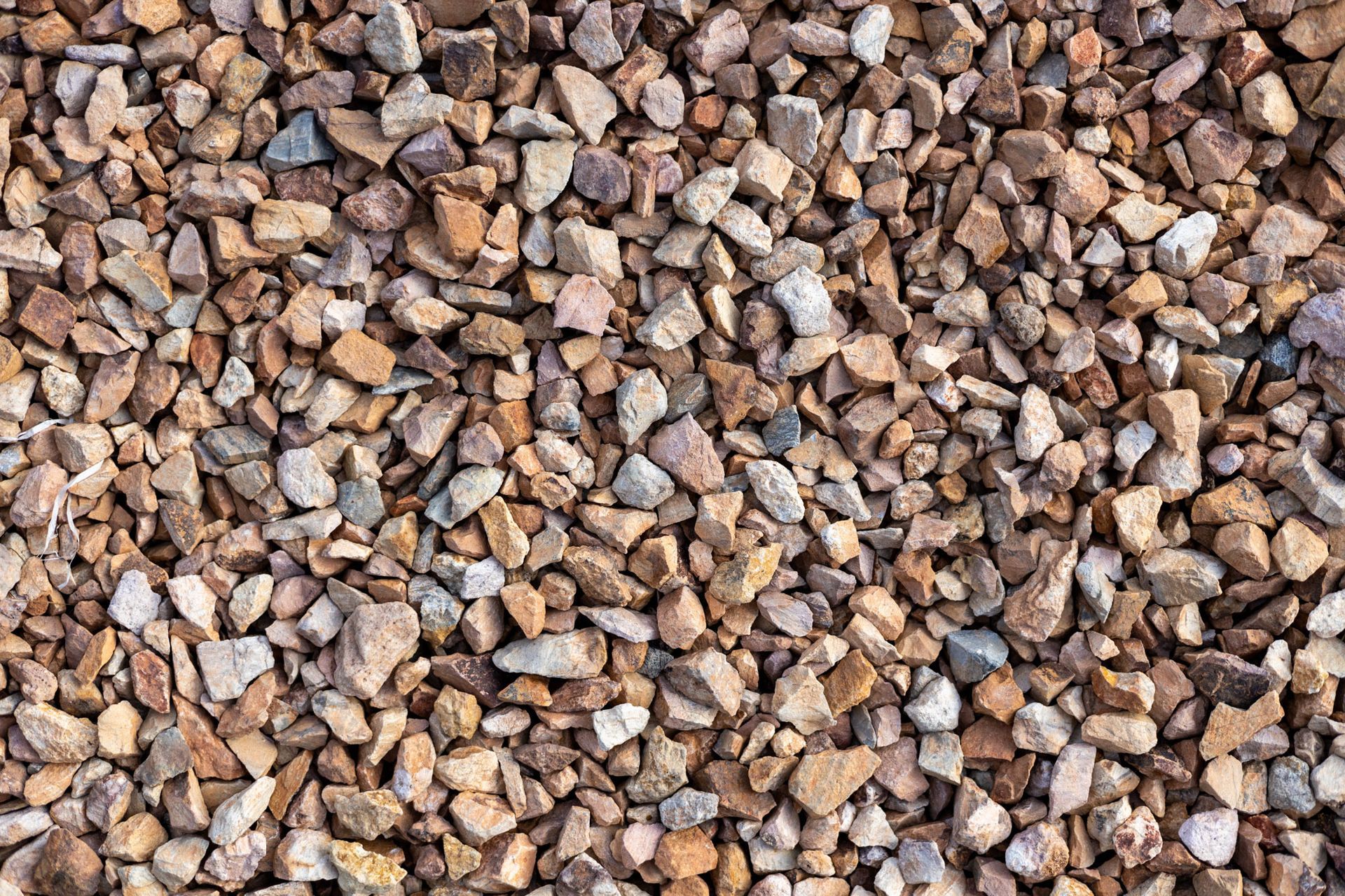 Close-up of small tan, brown, and gray gravel stones filling the frame