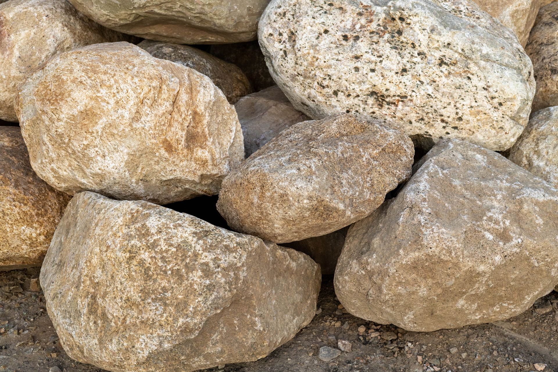 Pile of light tan and gray rocks stacked closely together
