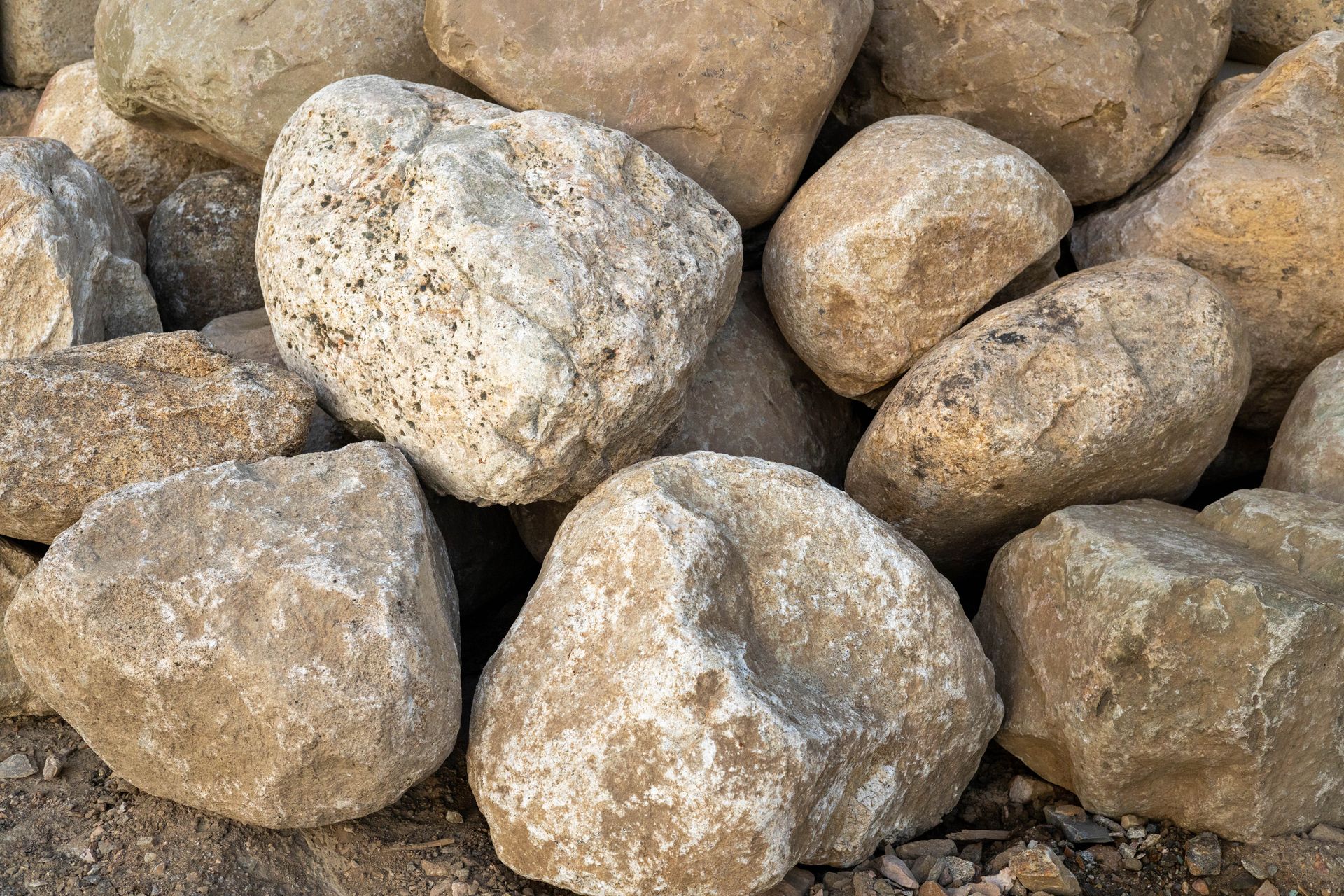 Pile of light tan and gray rocks stacked closely together