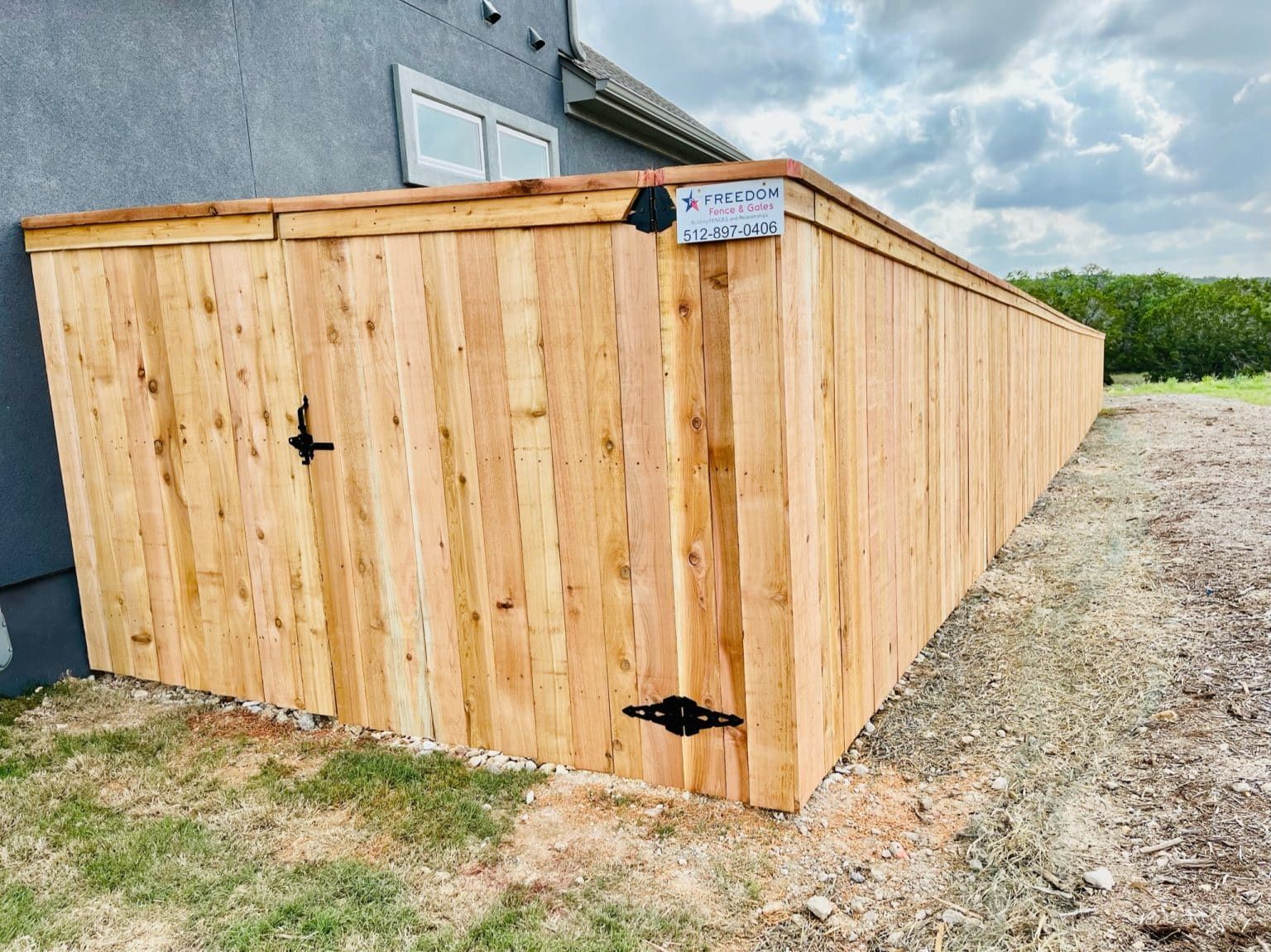 A wooden fence is sitting on the side of a house.