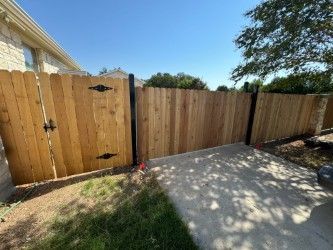 A wooden fence with a gate in the backyard of a house.