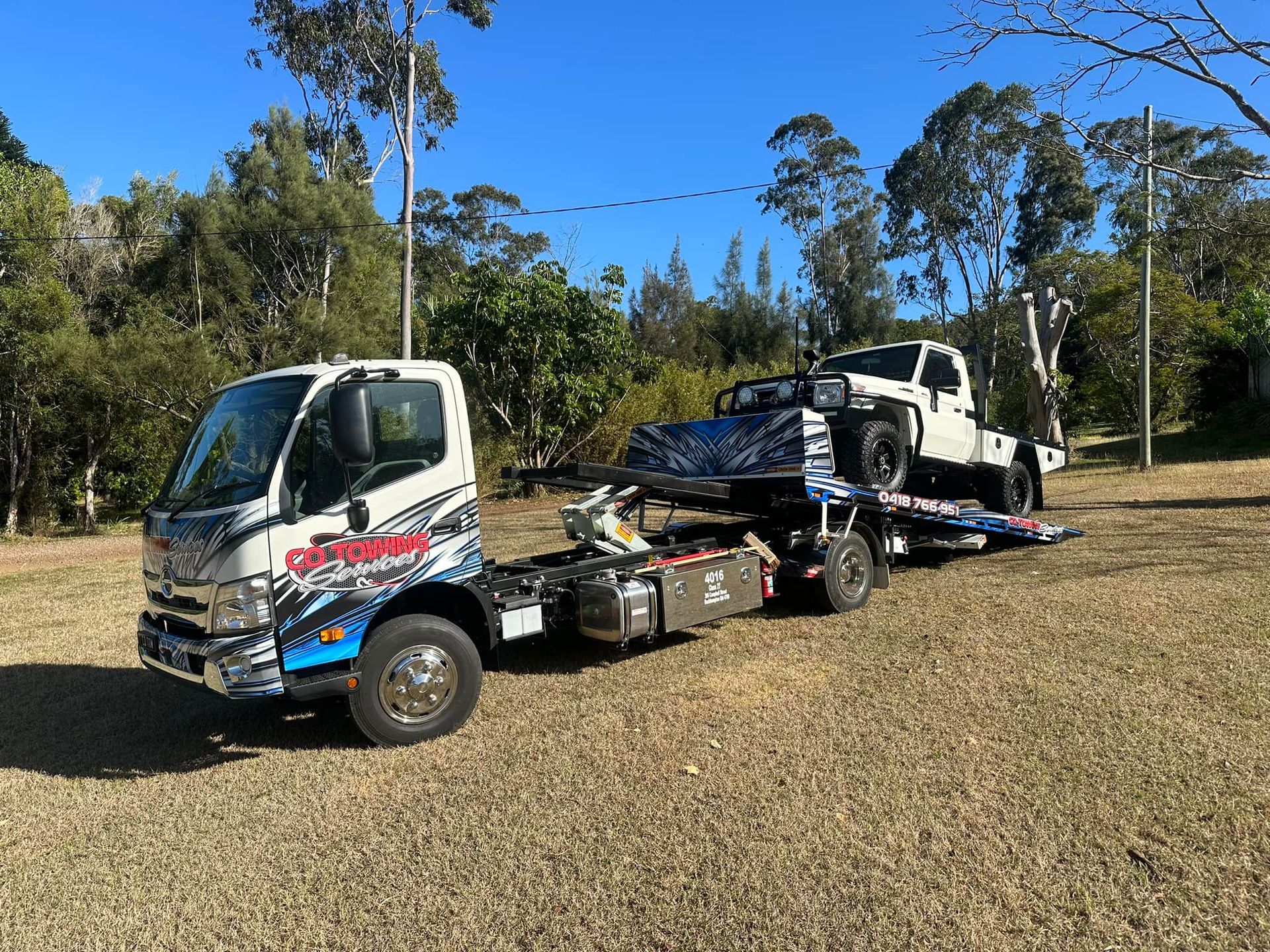Tow Truck with A White Pickup Truck Loaded on Its Flatbed — Cq Towing Services In Rockhampton City, QLD