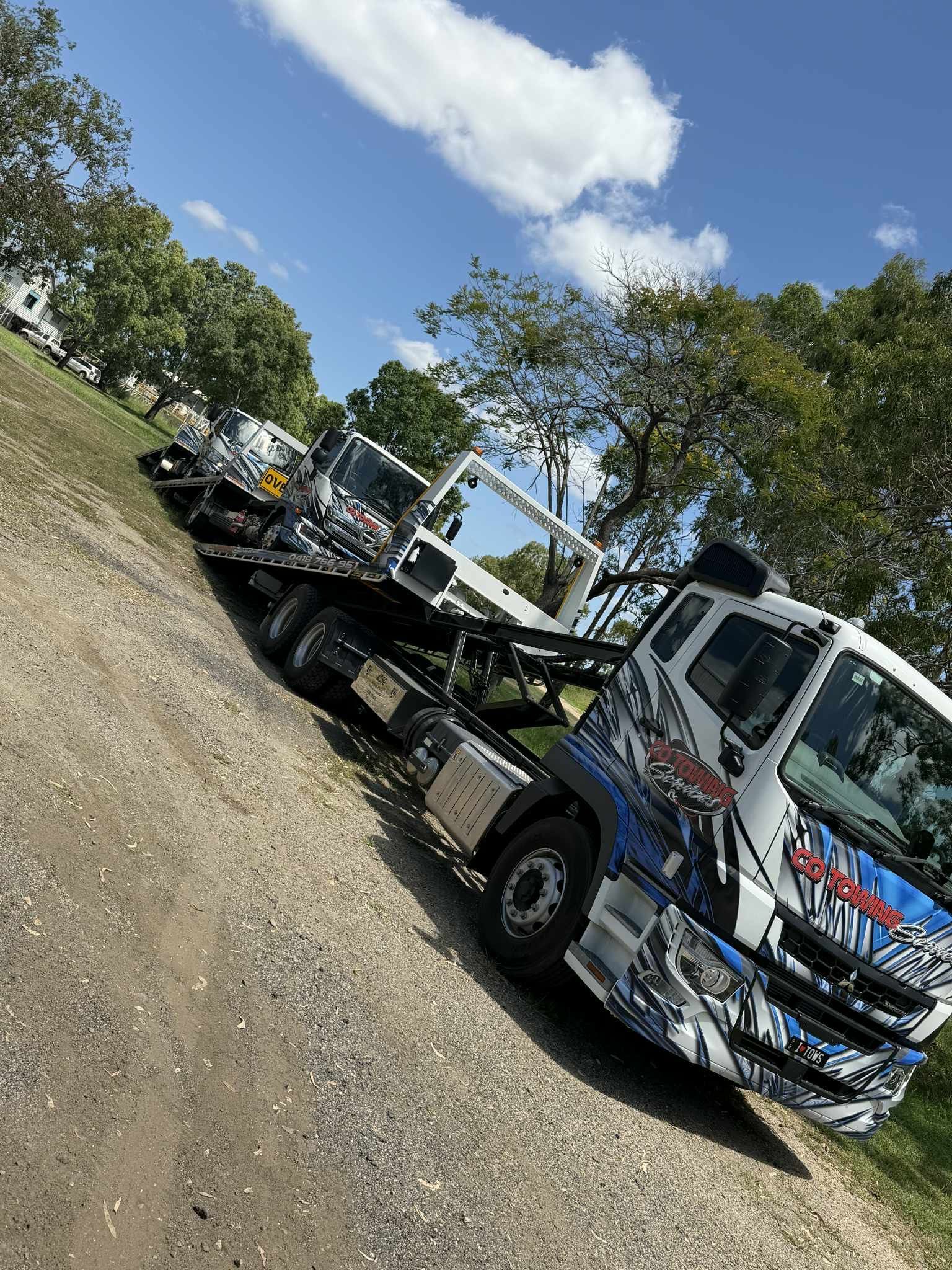 A White Sedan Car Is Loaded on A Tow Truck Inside a Garage — Cq Towing Services In Rockhampton City, QLD
