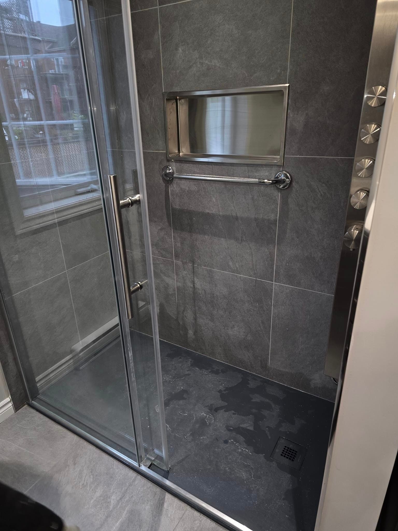 Une salle de bain avec douche à l'italienne avec porte coulissante en verre.