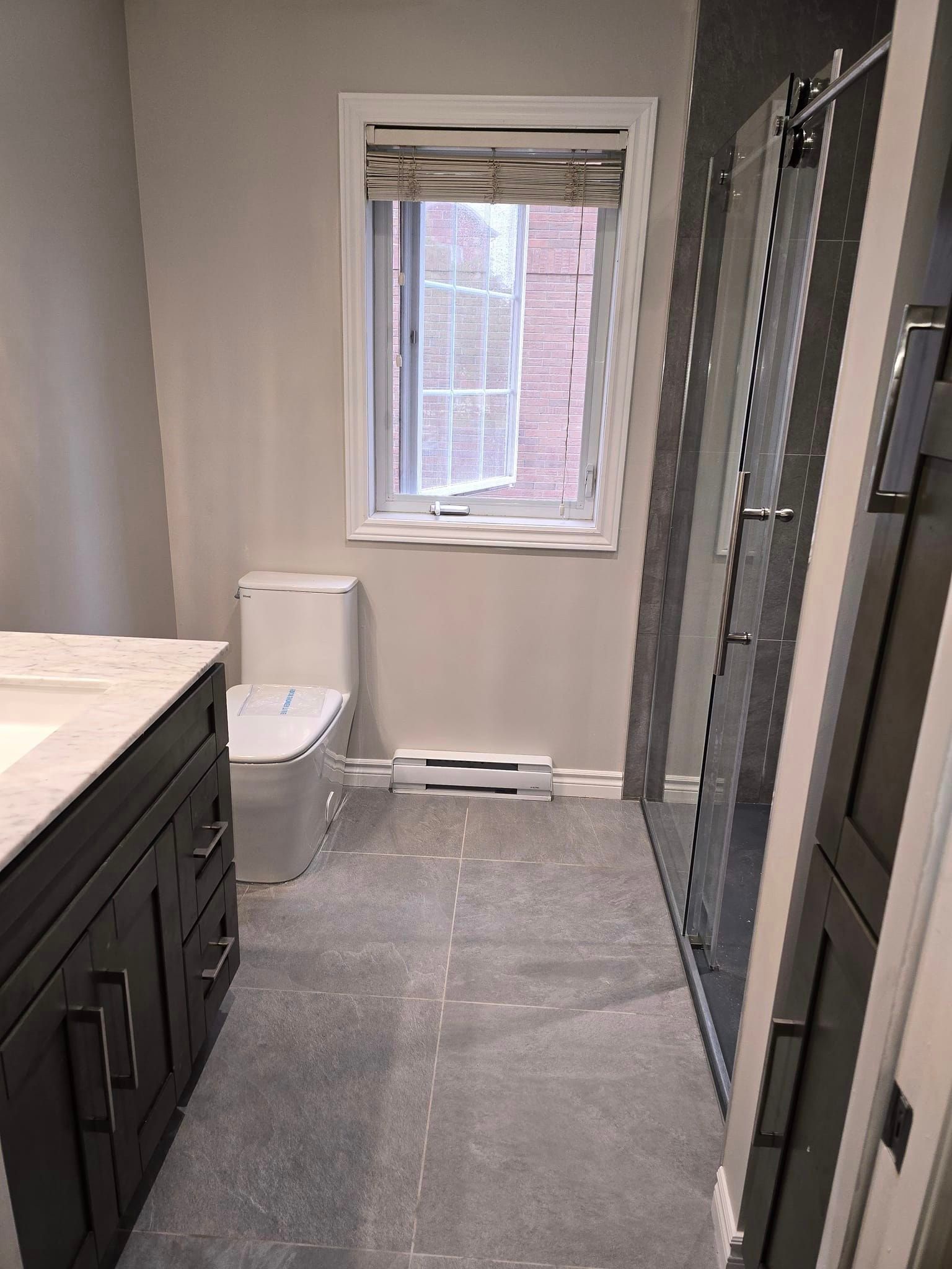 Une salle de bain avec WC, lavabo et douche.