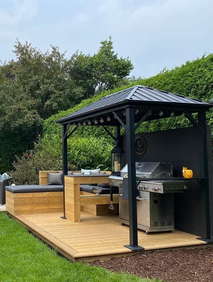 Une terrasse en bois avec un gazebo et un barbecue dans la cour arrière.