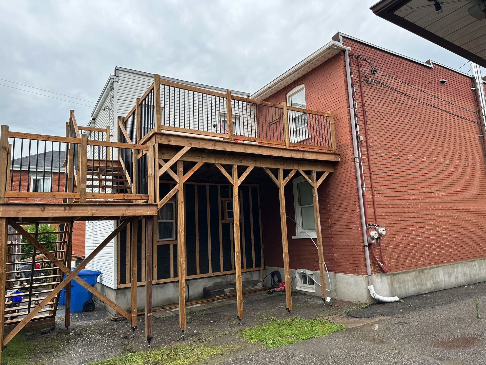 Une maison en brique avec une terrasse en bois attachée.