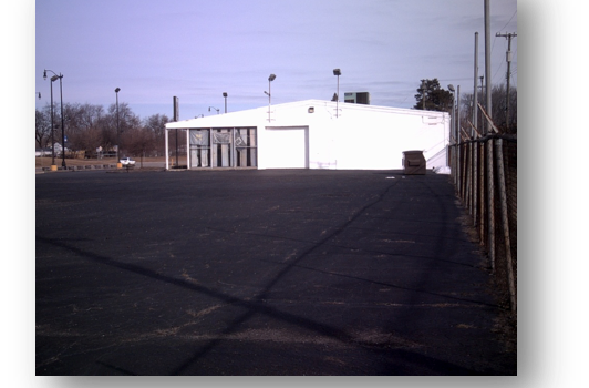 A Large White Building With A Fence In Front Of It