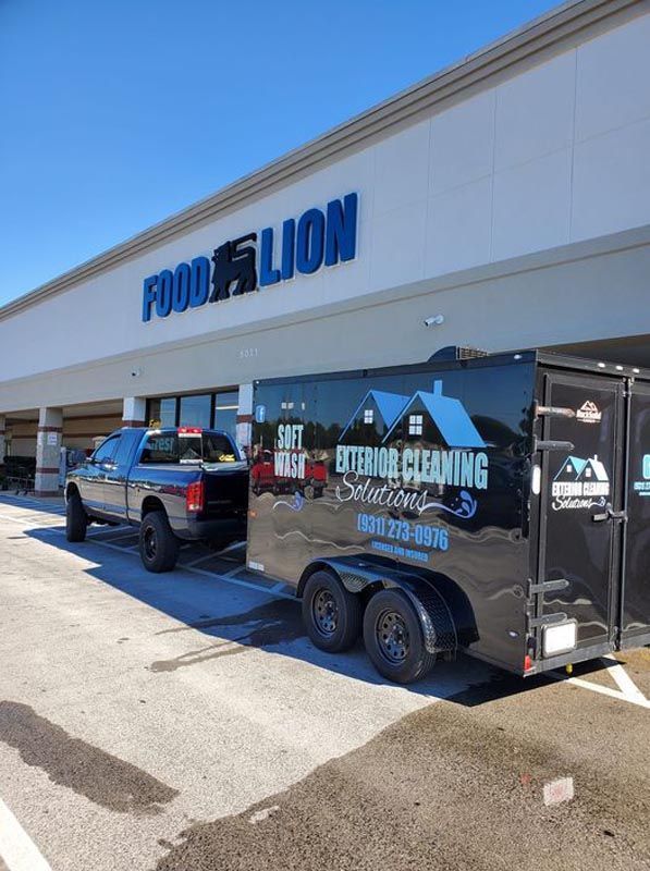 A truck and trailer are parked in front of a building that says food lion
