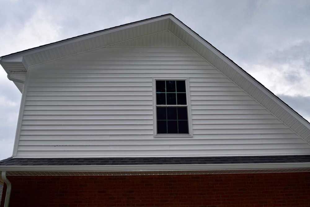 The roof of a house with a window on it.