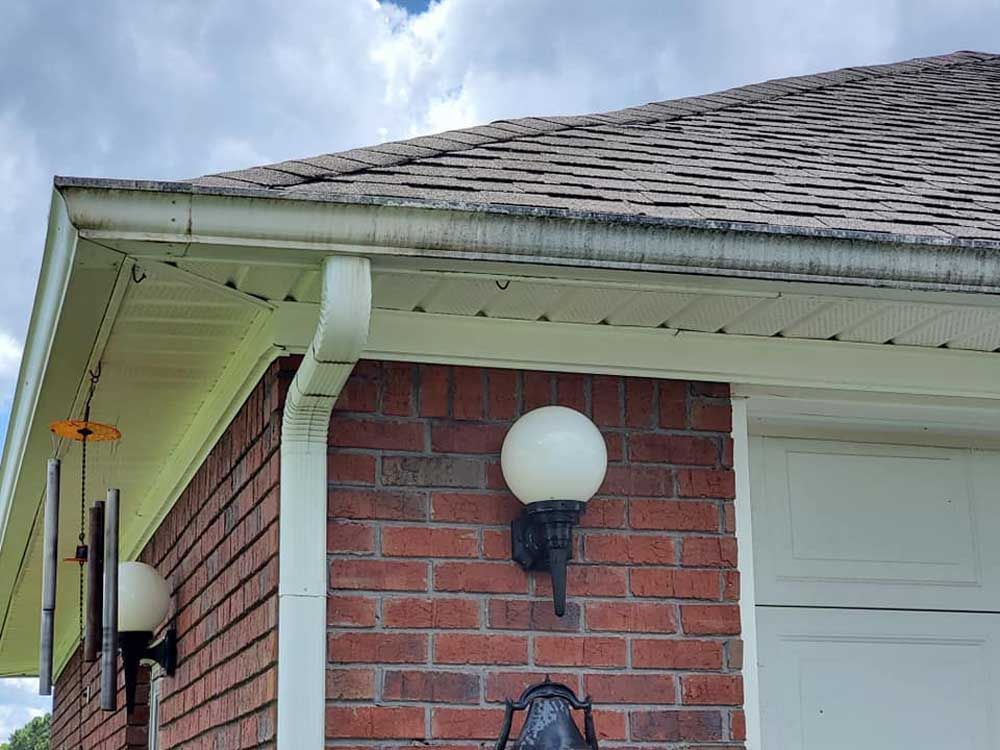 A brick house with a white garage door and a light on the side of it.