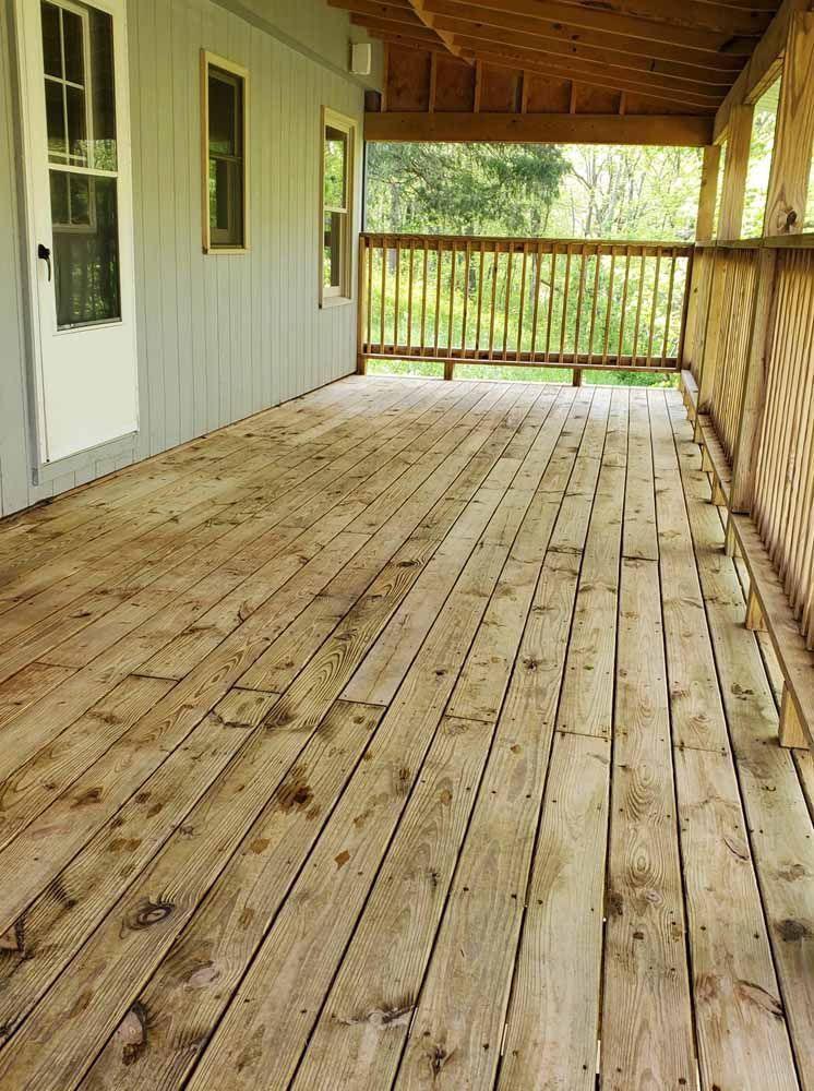 A wooden deck with a railing and a white door
