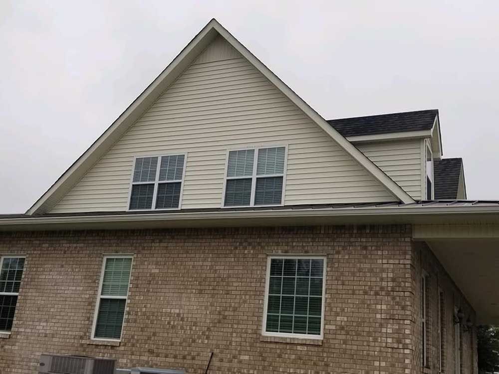 A brick house with a white roof and a lot of windows