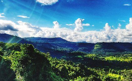 The sun is shining through the clouds over the mountains