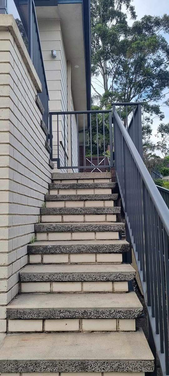 Set Of Stairs Leading Up To A Building With A Grey Aluminium Railing — Decorative Aluminium Works In Cardiff, NSW