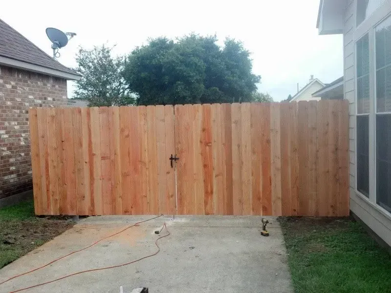 Wooden fence with a gate in a backyard.