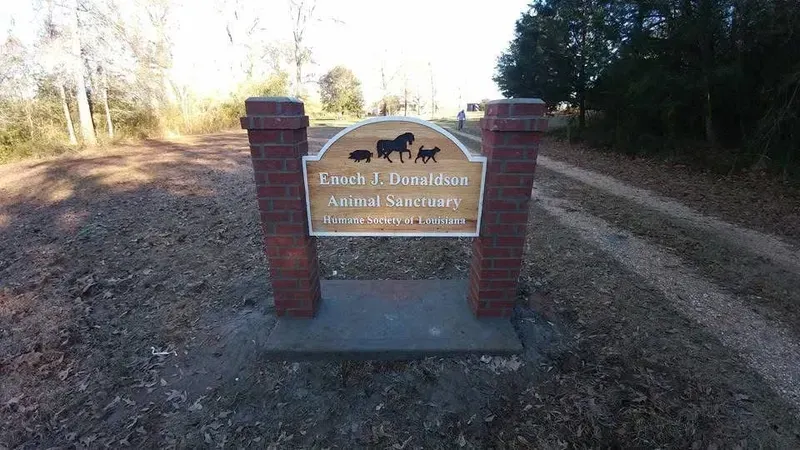Sign for Sarah J. Davidson Animal Sanctuary; brick pillars flank a wooden sign with animal silhouettes