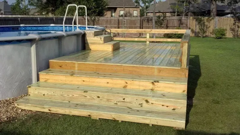Wooden deck and steps leading to an above-ground swimming pool in a backyard.