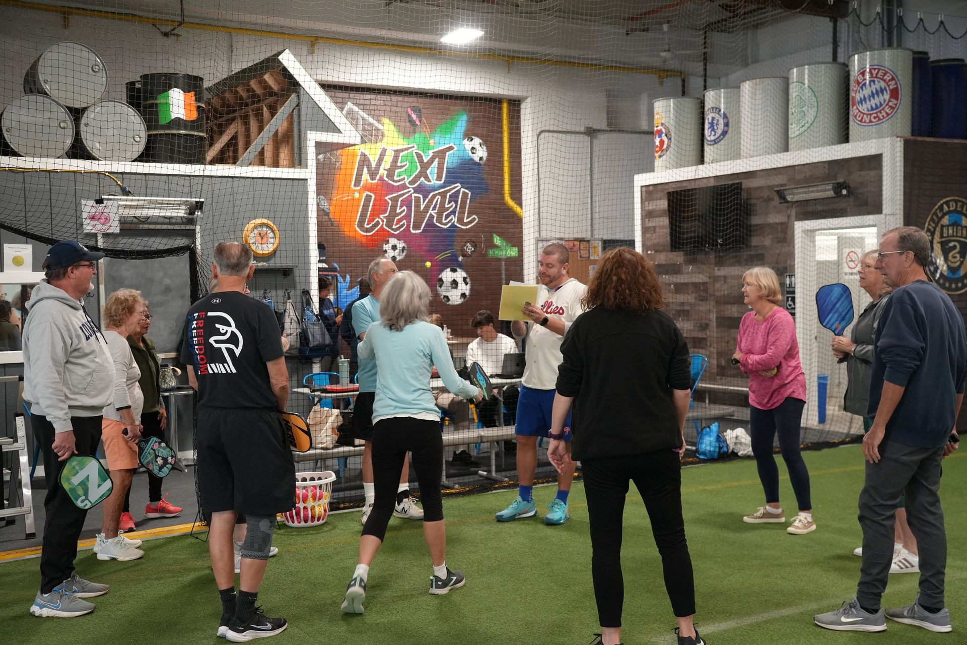 A group of people are standing in a circle in a gym.