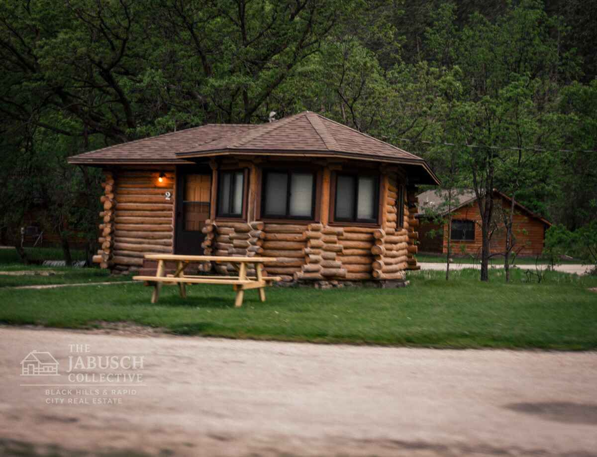 A Black Hills log cabin for sale with a bench in front