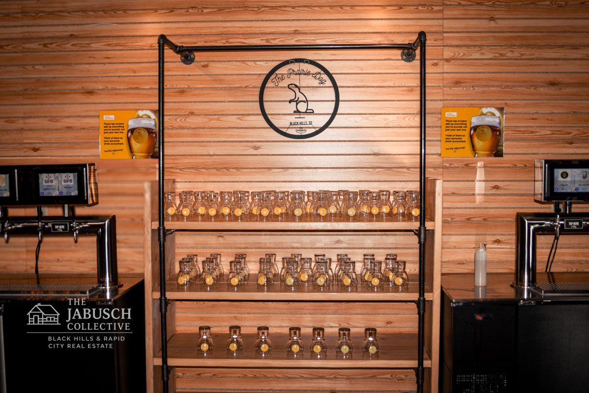 The Prairie Dog Bar interior with beer taps, glass shelves holding glasses, and wooden backdrop.