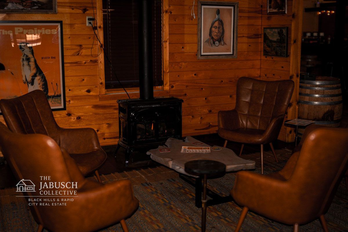Cozy room at the Prairie Dog Taproom with leather chairs, fireplace, wooden walls, and vintage artwork.