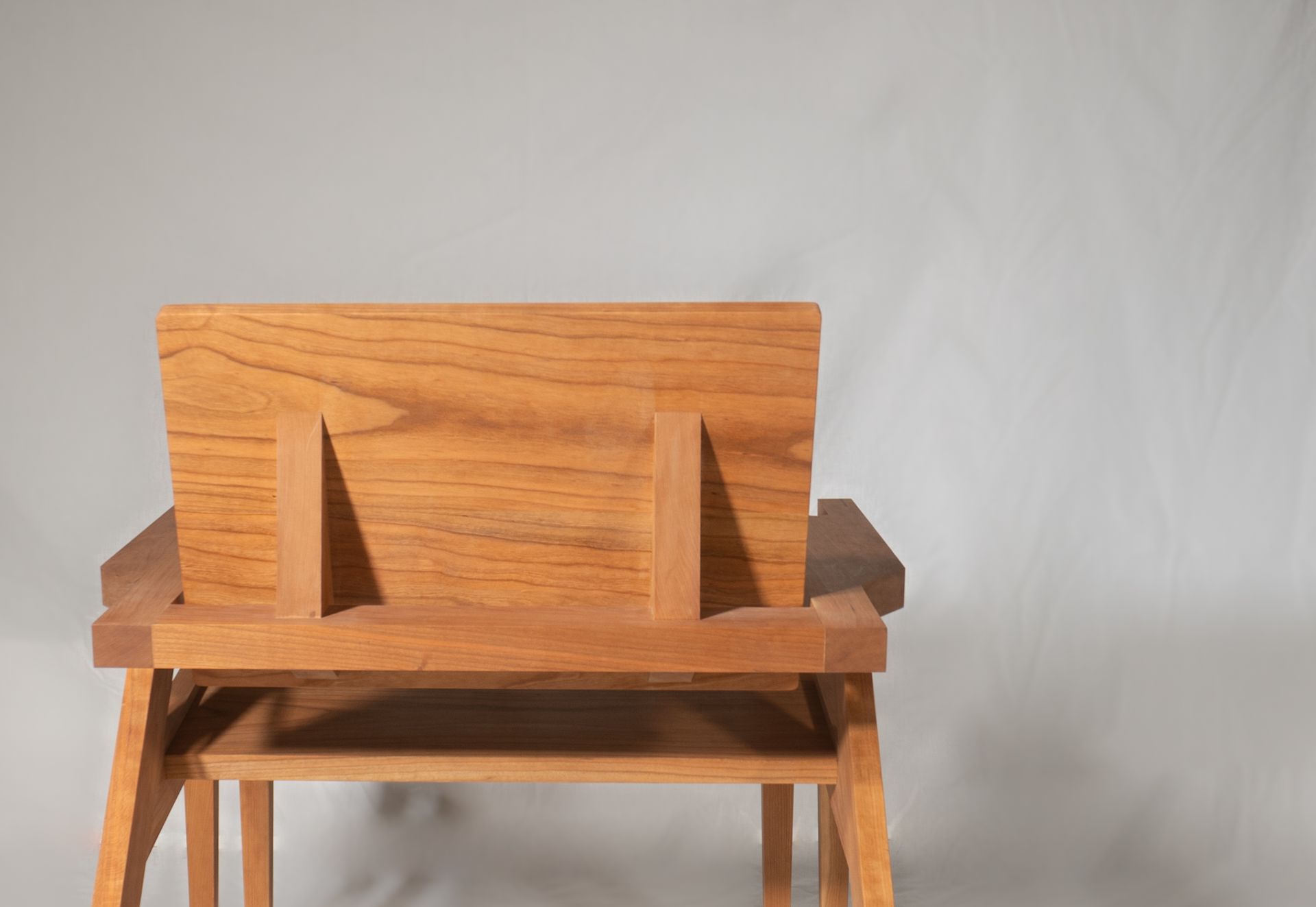 the back of a handmade cherry lounge chair built and designed by Crow and Timber
