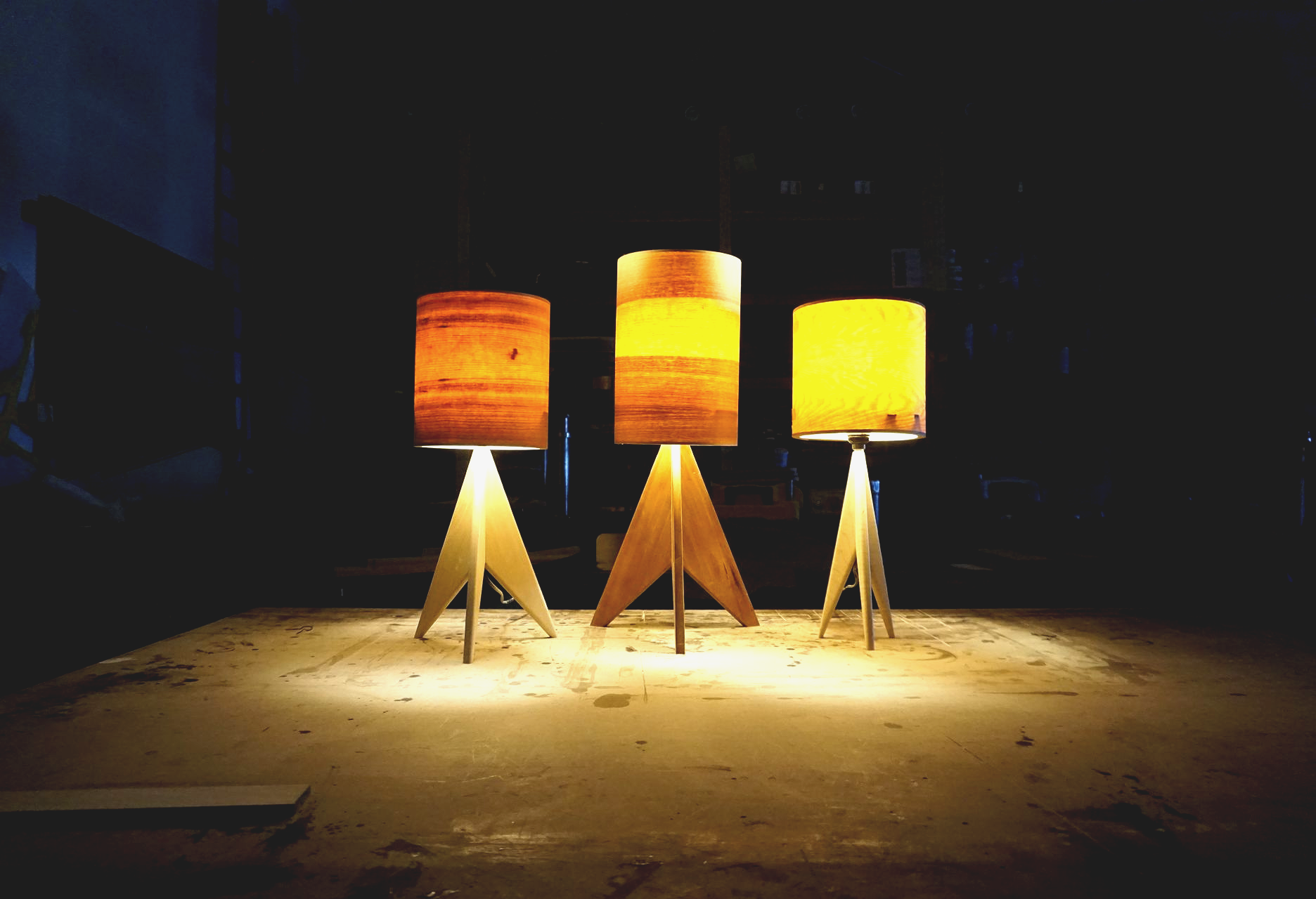 Handcrafted wooden tripod lamps with glowing veneer lampshades, designed by Crow and Timber to showcase modern craftsmanship