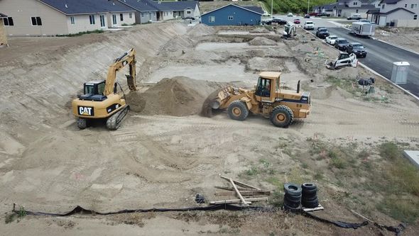 A cat excavator and a bulldozer are working on a construction site.