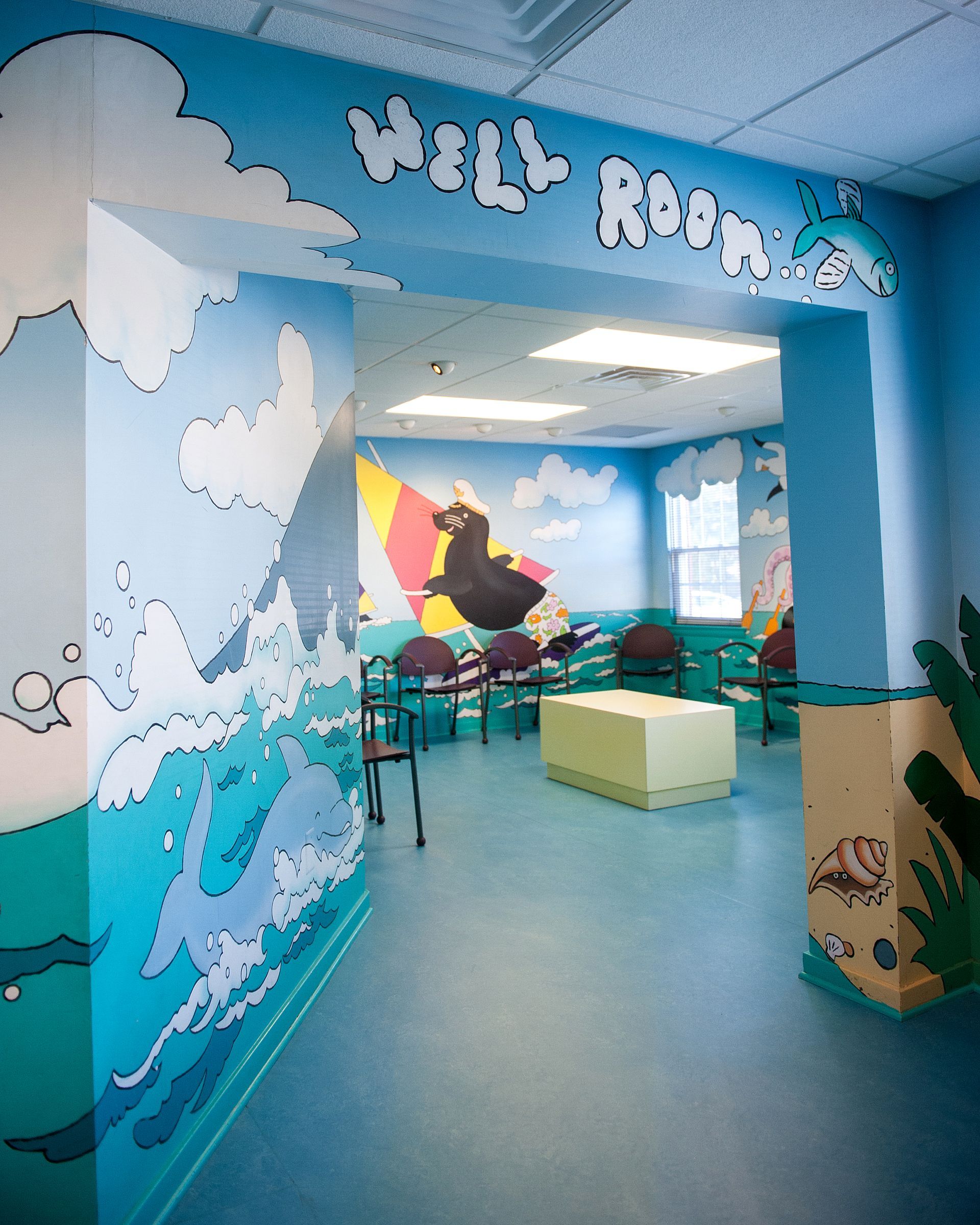 Well waiting area with colorful mural on the walls at a pediatricians office