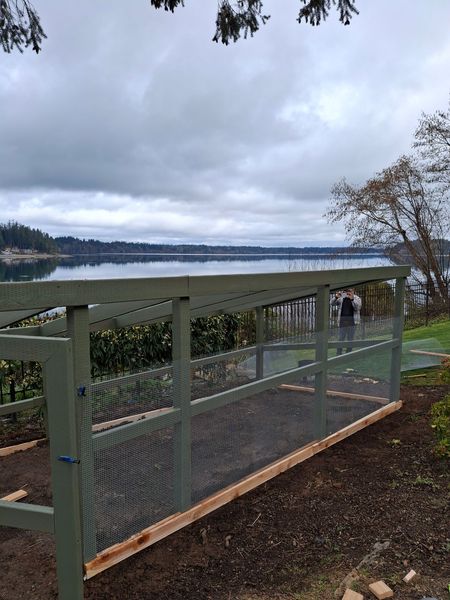 A fence with a view of a lake behind it.