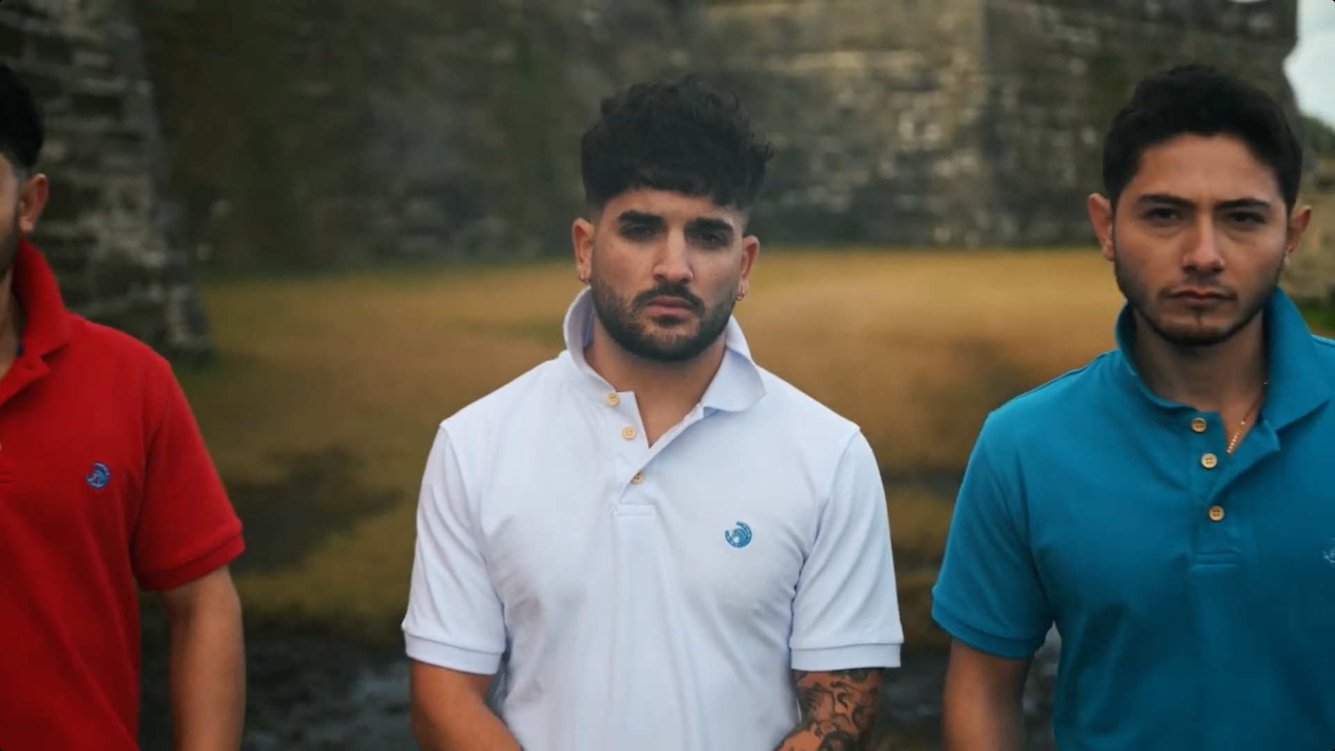 Three men are standing next to each other wearing polo shirts.