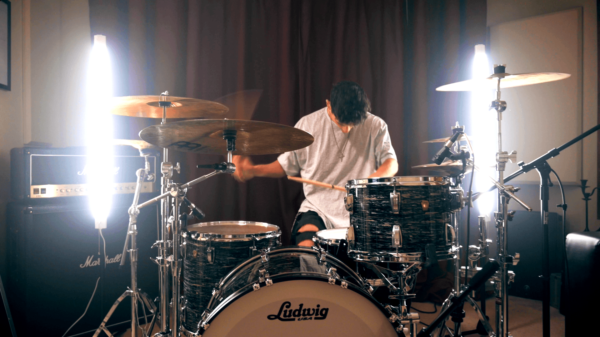 A man is playing drums in a room.