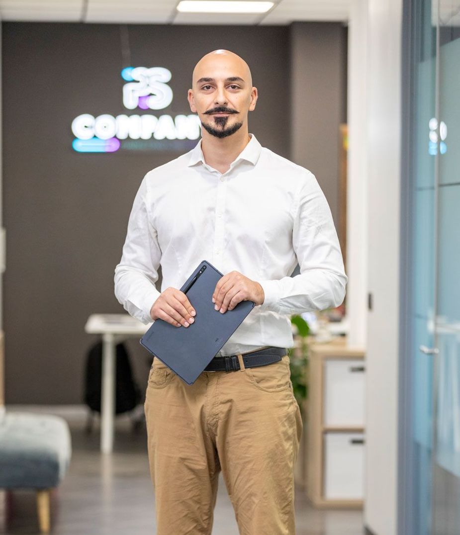 Un uomo con una camicia bianca e pantaloni color cachi è in piedi nel corridoio e tiene in mano una cartella.