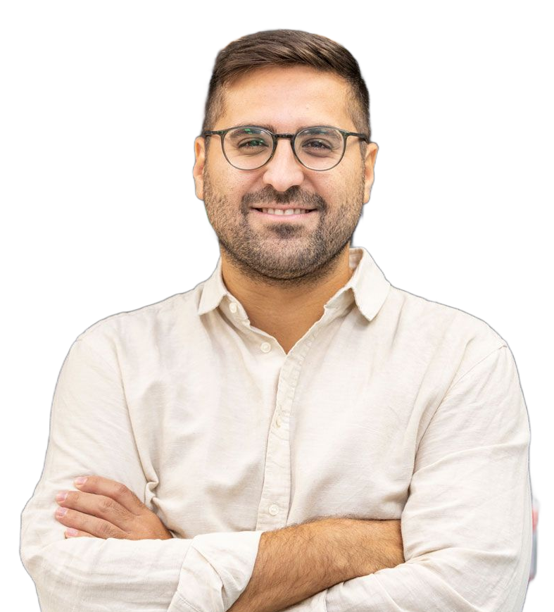 Un uomo con gli occhiali è in piedi davanti a una lavagna con le braccia incrociate.