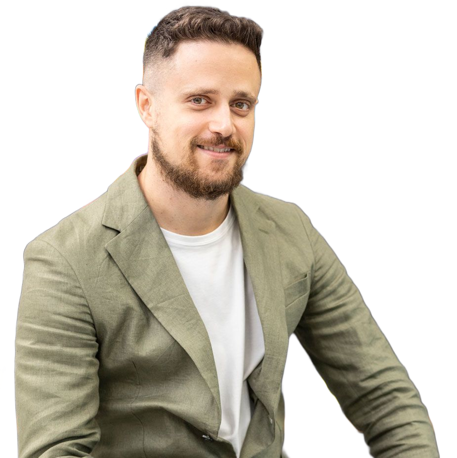 Un uomo è seduto a una scrivania e tiene in mano un bicchiere pieno di liquido blu.