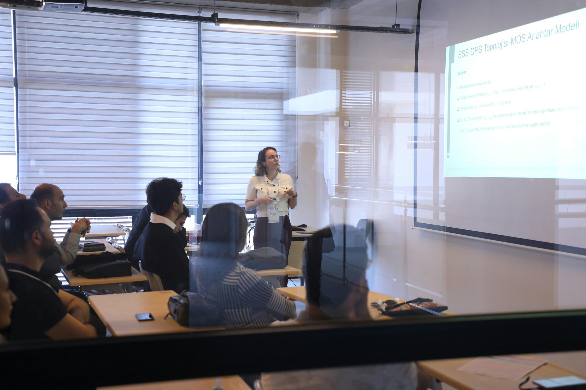 Una donna sta tenendo una presentazione a un gruppo di persone in una classe.
