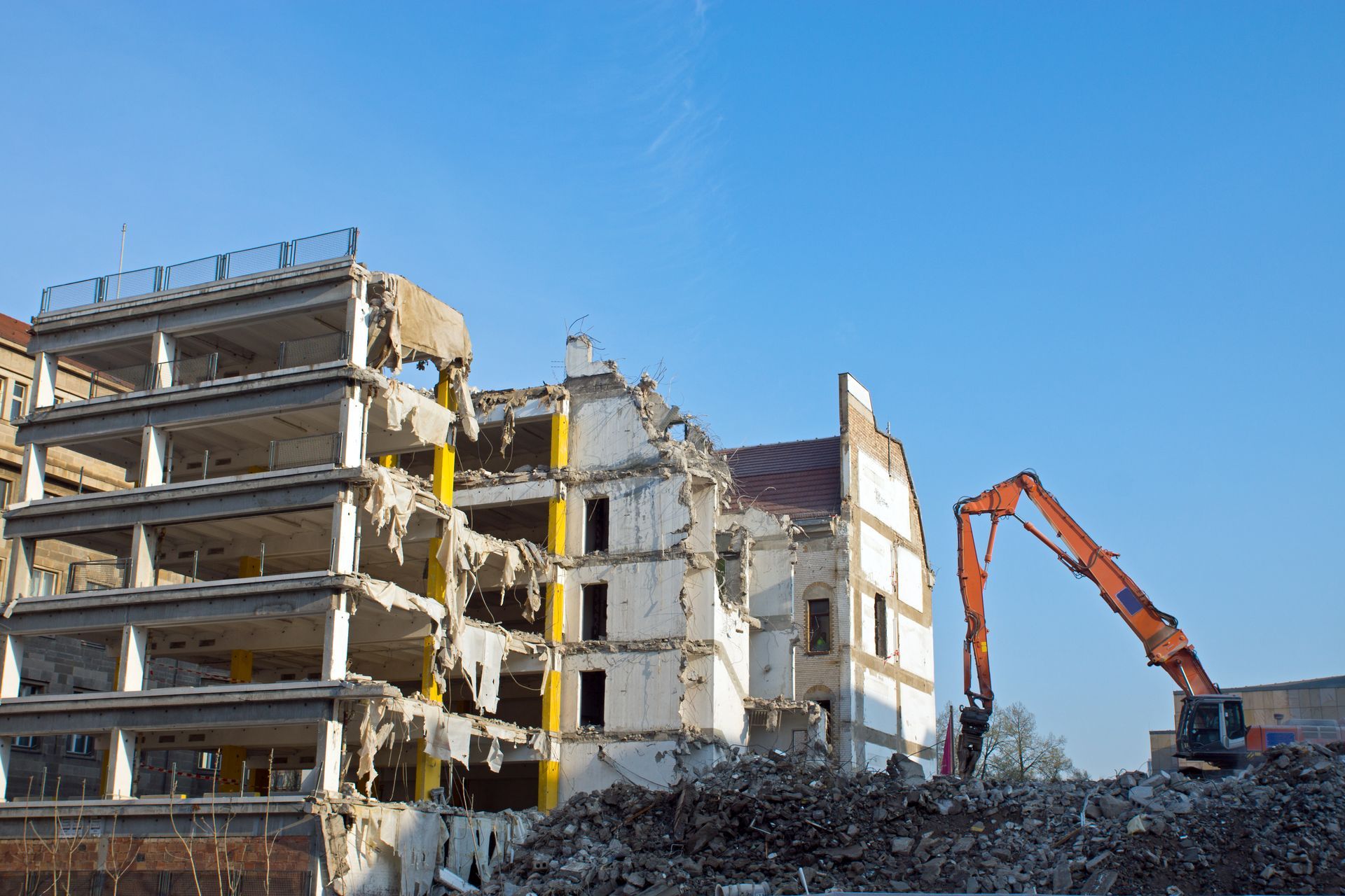 Building demolition following asbestos abatement as part of industrial site dismantling services