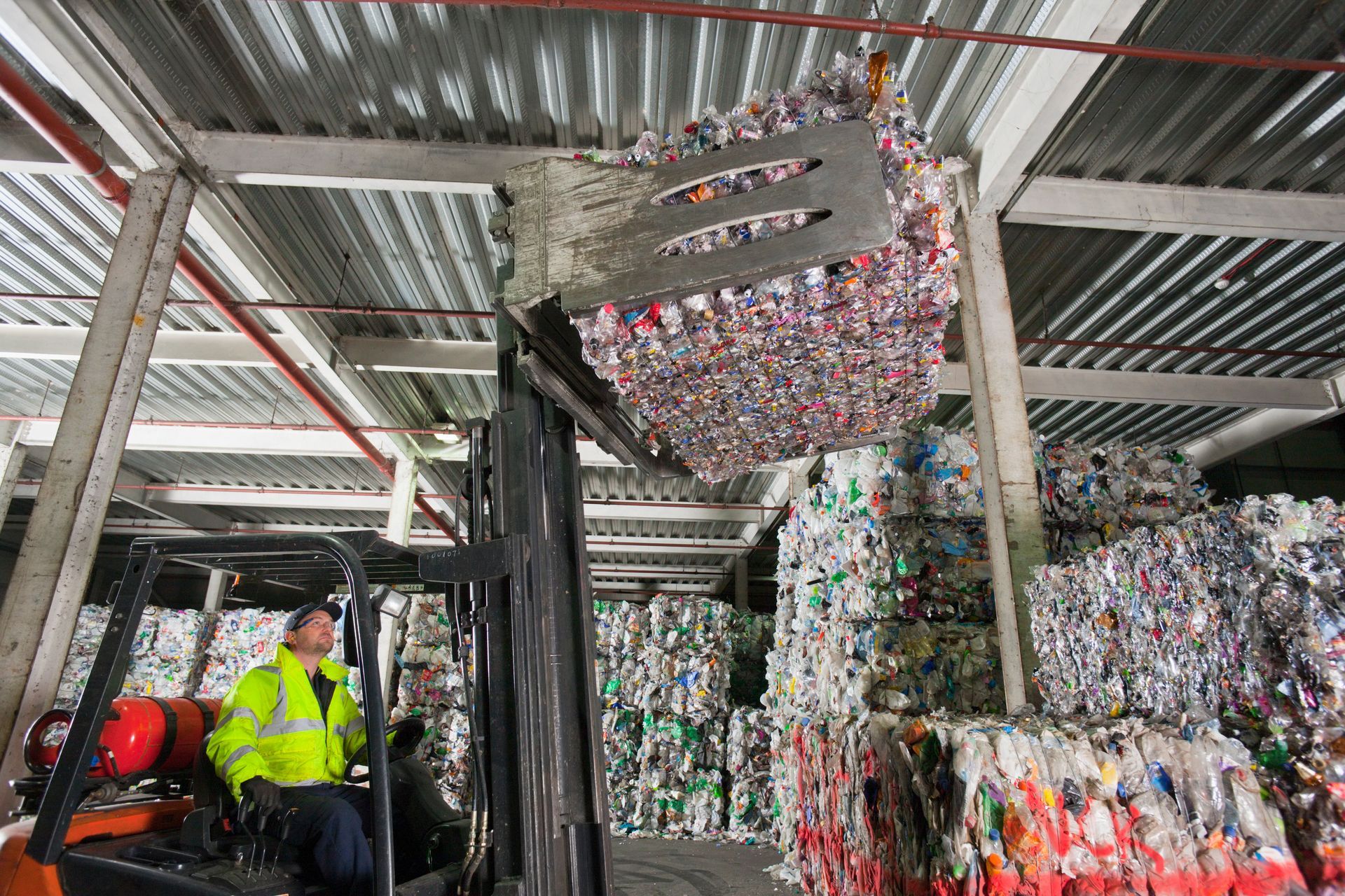 Forklift handling baled non-hazardous industrial waste for compliant bulk waste disposal