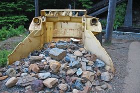 Heavy equipment loading industrial waste debris for transport and compliant disposal
