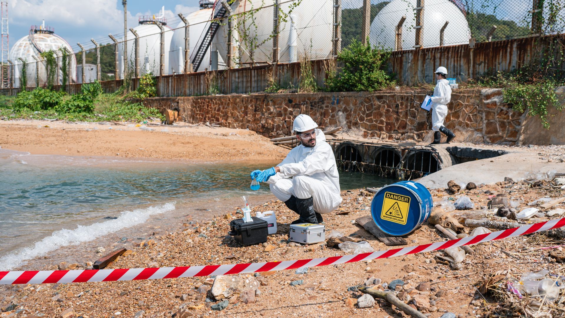 Hazmat technicians sampling contaminated water during asbestos removal and environmental remediation services
