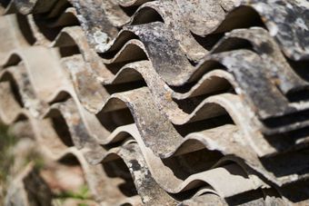Close-up of asbestos-containing building materials during licensed asbestos abatement and removal process
